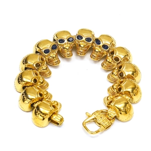 Dettaglio del bracciale a maglie con teschi dorati e occhi in cristallo blu scuro