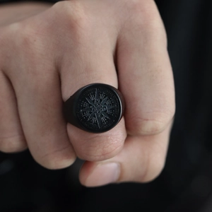 Primer plano macro de anillo de sello negro mate con brújula grabada para hombre punk