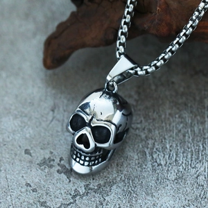 Detail of vintage 3D skull pendant with rugged texture and stainless steel box chain