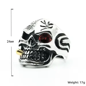 Gothic punk skull ring in silver steel with red eye accents and golden pipe detail