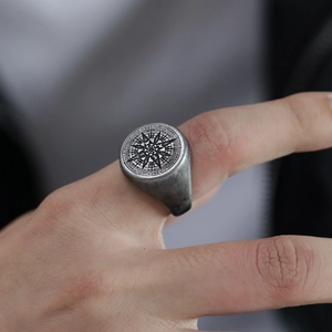 Vista macro del anillo de sello para hombre en acero con brújula y grabado interno