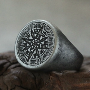 Detalle macro de un anillo de sello punk de acero inoxidable con grabado de brújula