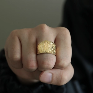 Close-up of a gold poker royal flush ring worn on a fist with a hip-hop style