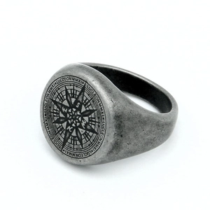 Detalle macro del anillo de brújula de acero para hombre con acabado antiguo y grabado Lucleon