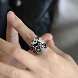 Close-up of punk style skull ring with white bead eye inlay and vintage metal finish