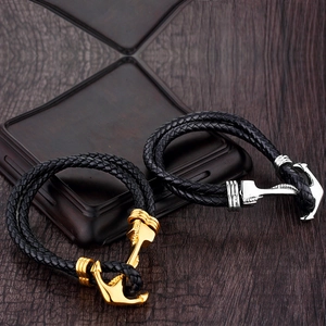 Bracciale in pelle intrecciata con fibbia ad ancora oro e argento su base in legno