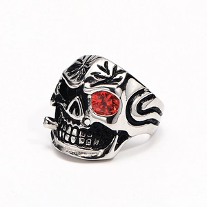 Macro detail of punk skull ring with red rhinestone eye and silver-tone metal texture
