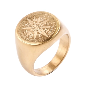 Vista macro de anillo de sello dorado en acero con grabado detallado de rosa náutica