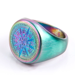 Detalle macro de anillo de sello de acero arcoíris con brújula y grabado LUCLEON