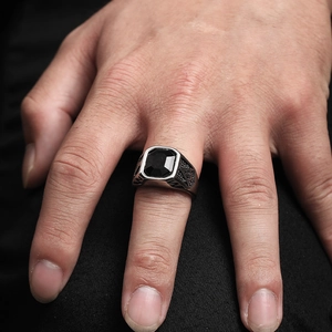 Detail showing vintage engravings and square black gemstone on silver masonry ring