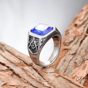 Men's silver-toned Freemason ring with blue square stone on a natural wood bark background