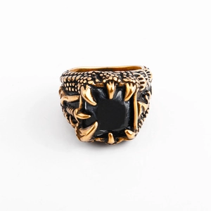 Macro shot of gothic eagle claw ring featuring a large black gemstone and scale texture