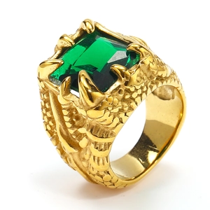 Macro detail of men's eagle claw ring with green rectangle gemstone and gold scale texture