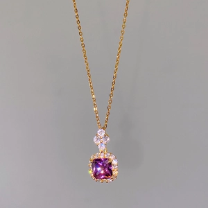 Close-up of a square purple zircon pendant on a gold halo chain with small clear diamonds