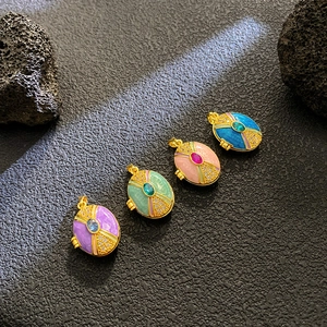 Detailed view of vintage locket pendants with colorful enamel and sparkling zircon accents