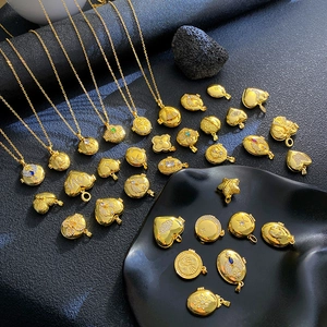 Detailed macro view of various gold locket pendants featuring zircon-inlaid star and moon