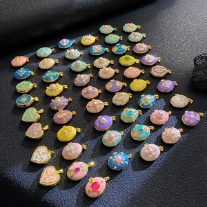 Macro display of colorful vintage enamel heart and oval pendants with pearls and zircons