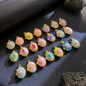 Detailed view of colorful enamel egg lockets with gold plating and rhinestones