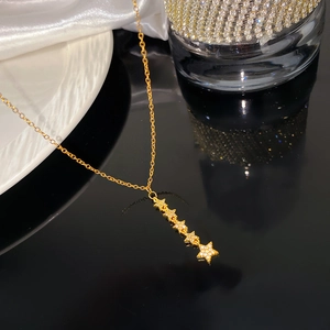 Detailopname van de gouden vijfsterrenketting met ingelegde zirkoon op een glanzende zwarte