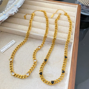 Bracelets gourmette cœur doré avec zircons blancs et noirs sur un plateau en velours beige