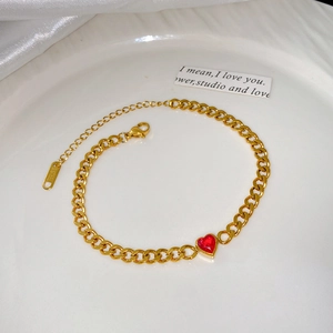 Détail d'un bracelet chaîne en acier doré orné d'une pierre de zircon en forme de cœur