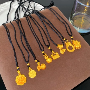 Collection of eight gold-plated charms with black cords on a brown display stand