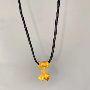 Detail of gold lotus seed pod pendant necklace with black cord in Chinese style