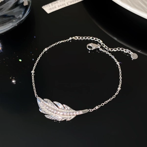 Macro shot of silver feather bracelet featuring sparkling cubic zirconia and S925 stamp detail