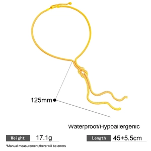 Detailweergave van de gouden slangenketting met elegant knoopontwerp en kwastje aan het uiteinde