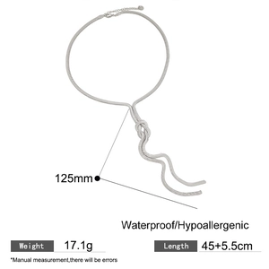 Detail van zilveren slangenketting met knoopaccent en lange franjes voor damesstijl