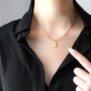 Close-up of golden titanium steel snake chain featuring a Lucky 7 rectangular pendant
