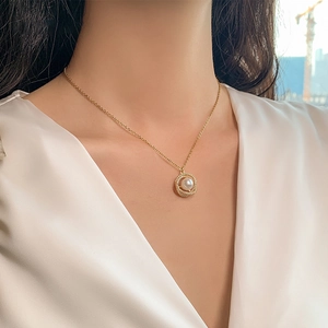 Close-up of a gold 18k plated necklace with a pearl and crystal pavé hollow ring pendant