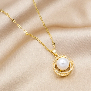 Detailed close-up of a 18k gold plated pearl pendant necklace on champagne silk fabric