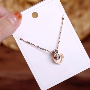 Rose gold heart and zircon ring interlocking pendant necklace on display card