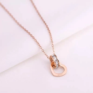 Close-up of rose gold heart pendant with Love engraving and crystal pavé circle