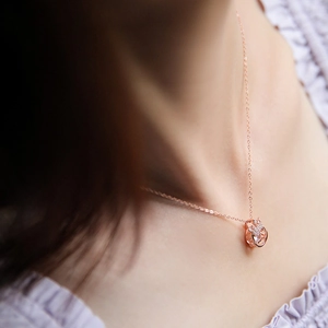 Elegant rose gold crown necklace with dancing stone pendant on model's neckline