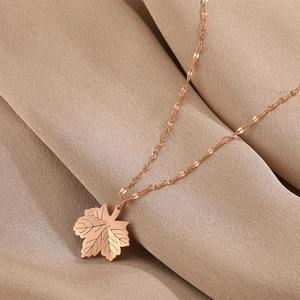 Detailed close-up of rose gold maple leaf pendant with vein engravings and decorative chain