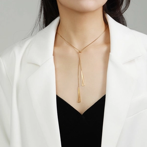 Rose gold titanium triangular geometric Y-necklace worn by model in elegant business attire