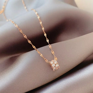 Elegant rose gold hourglass necklace with cubic zirconia on smooth satin background