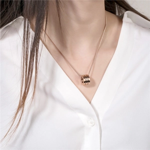 Collier minimaliste en titane or rose avec pendentif cristal sur mannequin en chemise