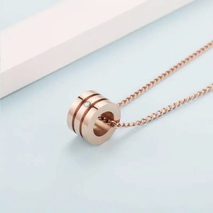 Collier minimaliste en acier titane or rose avec pendentif cylindre et zircon cubique