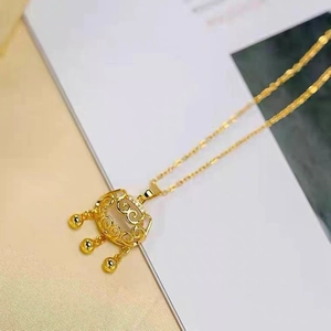 Dettaglio della collana dorata con ciondolo a lucchetto della longevità e tre campanelli
