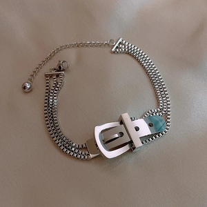 Nahaufnahme des dreilagigen silbernen Box-Chain-Armbands mit Gürtelschnallen-Detail