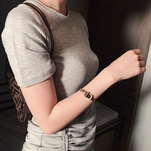 Detail eines goldenen Armbands im Gürtelschnallen-Stil aus Titanstahl am Handgelenk