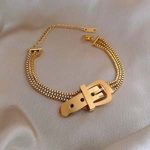 Detailansicht der Gürtelschnalle an einem dreisträngigen vergoldeten Box-Chain-Armband