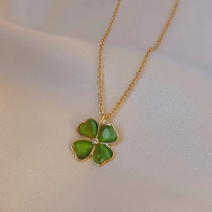 Elegant four-leaf clover pendant necklace with green cat-eye stone petals and gold chain