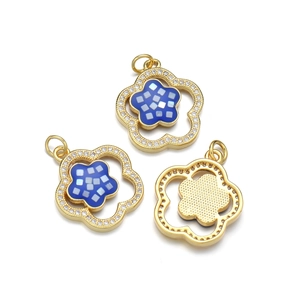 Pendentif fleur plaqué or avec zircons cubiques et émail bleu sur fond blanc épuré