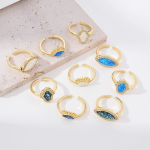Minimalistische 18K vergulde ringenset met Hamsa-hand en opaal op een stenen achtergrond