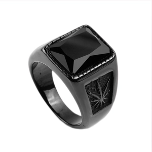 Détail macro d'une pierre noire carrée et gravures de feuilles sur bague en titane