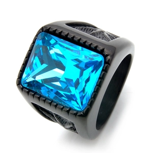 Détail macro d'une bague homme en acier noir avec relief d'aigle et pierre bleue